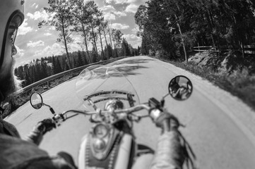 Biker man riding his motorbike on the open road up in the mountains, wearing leather gloves. Motion...