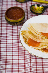 Delicious pancakes with red caviar on a table
