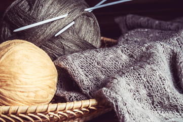 tangles of of woolen yarn and knitting needles in a basket