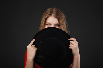Girl holding hat up to face
