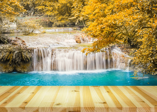 Waterfall, green forest in Erawan National Park in Thailand montage with wooden floor. Landscape with water flow, tree, river, stream and rock at outdoor. Beautiful scenery of nature for vacation. © DifferR