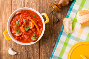 Delicious letcho with fresh vegetables, served in a yellow pot w