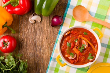 Delicious letcho with fresh vegetables, served in a yellow pot w