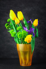 beautiful iris with tulips and green chrysanthemums in a vase on dark background dark wooden table