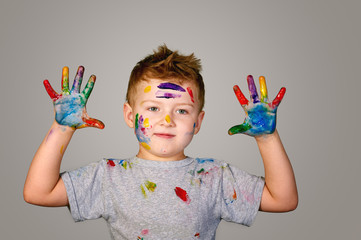 Boy with hands painted in colorful paints