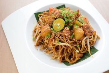 Asian style spicy fried noodles, ready to serve on dining table.