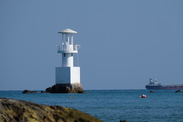 Fototapeta na wymiar Lighthouse on a sunny day with blue sea.
