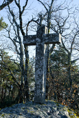 Stone cross in the forest.
