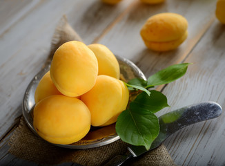 fresh apricots on the plate on a wooden background
