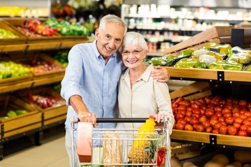 Portrsit of happy senior couple with cart