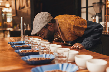 African man at a coffee tasting taking the aroma
