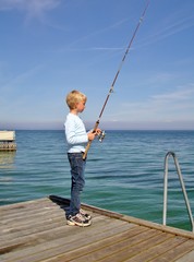 Young schoolboy hoping to catch a fish