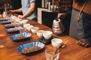 People with variety of coffee beans and cups at roastery