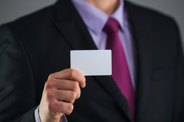 Business man showing a blank business card isolated, close up