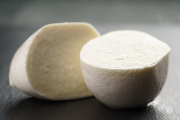 sliced mozarella ball on slate background, shallow focus