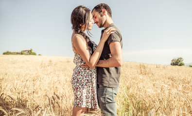 Young couple kissing in a wheat field