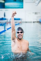 Handsome man triumphing with raised arms