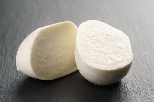 sliced mozarella ball on slate background, shallow focus