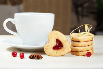 Obraz na płótnie Canvas Heart shaped cookies with jam and cup of tea