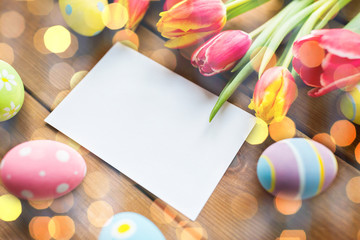 close up of easter eggs, flowers and white paper