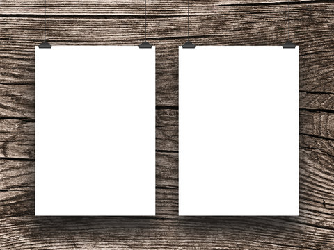 Close-up of two hanged paper sheet frames with clips on dark wooden background