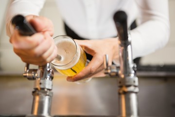 Masculine hands pouring a pint