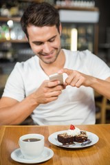 Handsome man taking a picture of his food