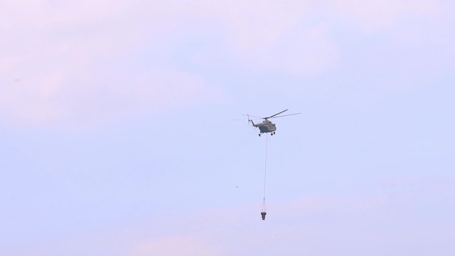 PERM, RUSSIA - JUN 27, 2015: Flying helicopter mi-26 with reservoir for extinguishing of forest fires on airshow Wings of Parma