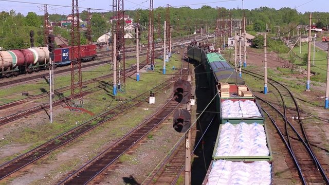 Top view of freight train with wagons filled with sacks of white on summer day