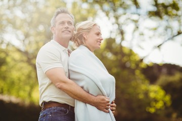 Obraz premium Husband hugging his wife in a blanket