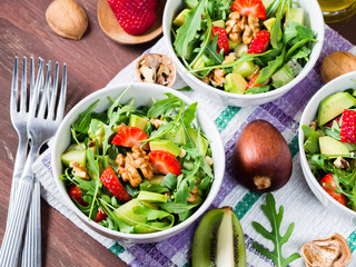 Avocado salad with arugula, strawberries, walnuts and kiwi