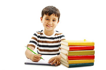 Smiling boy with school books on the table. Isolated on a white background 