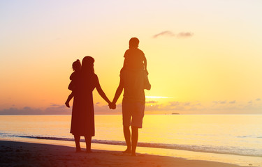 Fototapeta premium happy family with two kids walking at sunset