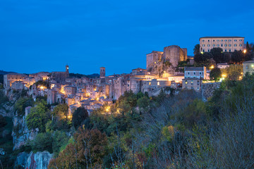 Sorano - tuff city in Tuscany. Italy. View in the dusk with illumination, travel background