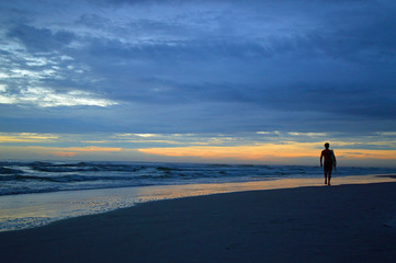 Jacksonville Beach, Florida, surfer at sunrise on the beach