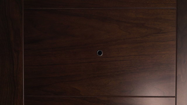 Male hand knocking at wooden door, visitor or guest at the door.