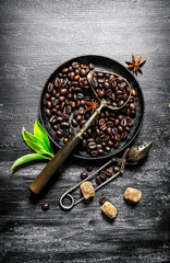 Roasted coffee beans in a frying pan.
