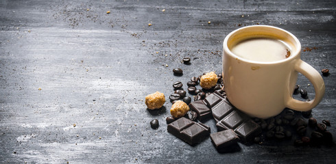 Cup of coffee with bitter chocolate and dark brown sugar.