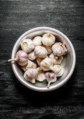 Fresh garlic in a metal bowl.