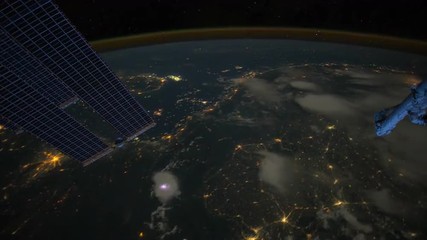 The International Space Station flies over the earth at night with storms and lightning strikes visible. - Powered by Adobe