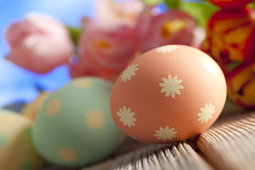 Fototapeta na wymiar Colorful Easter eggs and spring flowers on sky background