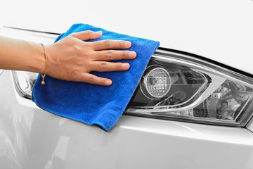Hand with microfiber cloth cleaning car