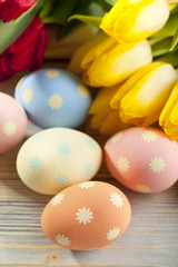 Obraz na płótnie Canvas Tulip flowers and Easter eggs on wooden table