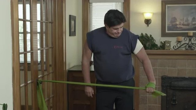 Man using elastic band to exercise his shoulder.