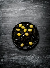 Olives and black olives in an old pan.