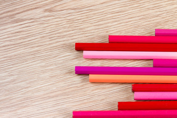 Obraz premium Colorful pens on wooden table. Equalizer concept