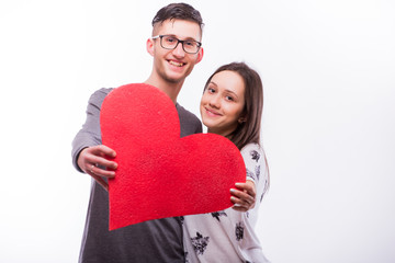 Romantic love hipster couple  with a red heart in hands look at camera. Caucasian couple against white background.