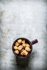 Mug with dark cane sugar. On stone background.