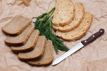 the cut bread on the paper with a dill and knife