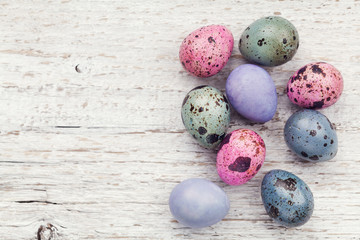 Painted easter eggs on rustic wooden background from above, vintage style, happy easter card